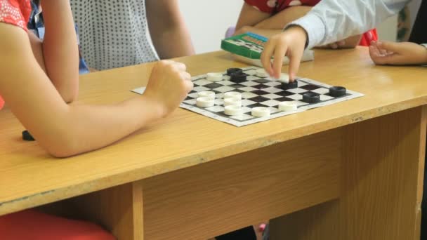 Kinderen spelen checkers op een kleuterschool. Close-up — Stockvideo