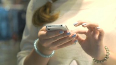 Kız gümüş smartphone tutar. Yakın çekim