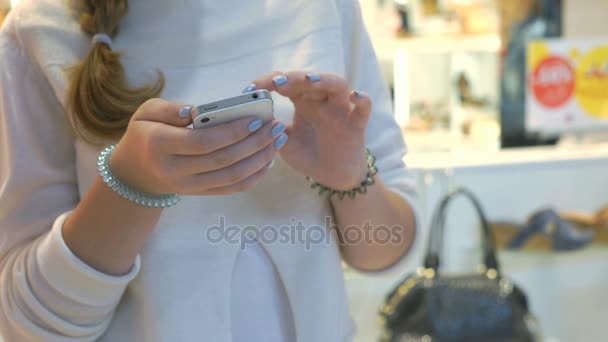 Chica sostiene teléfono inteligente de plata. Primer plano — Vídeo de stock