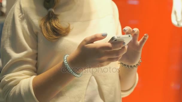 Fille tient smartphone argent. Gros plan 