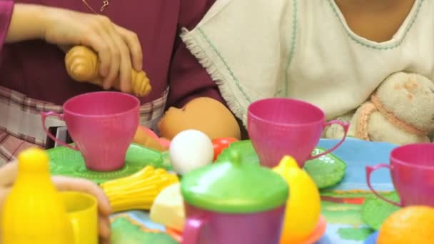 Child feeding doll food with plastic spoon — Stock Video