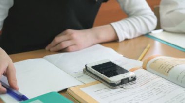 Kız öğrenci alıştırma kitabı kalem kullanarak metni yazar