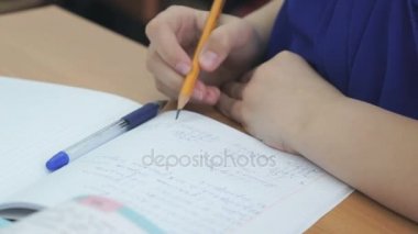 Bir çalışma kitabında bir tükenmez kalem ile öğrenci yazıyor