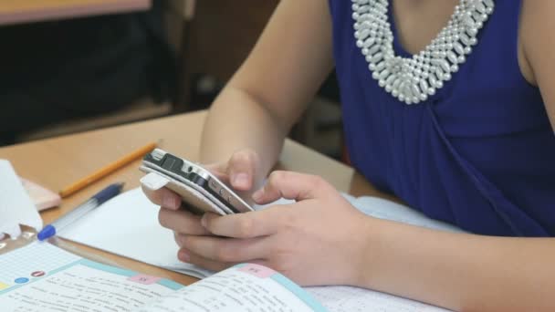 Colegiala vestida con vestido azul sostiene teléfono inteligente — Vídeos de Stock