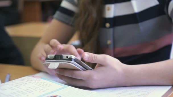 Школярка тримає срібний смартфон — стокове відео