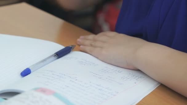 Estudiante escribe en un libro de trabajo con un bolígrafo — Vídeos de Stock