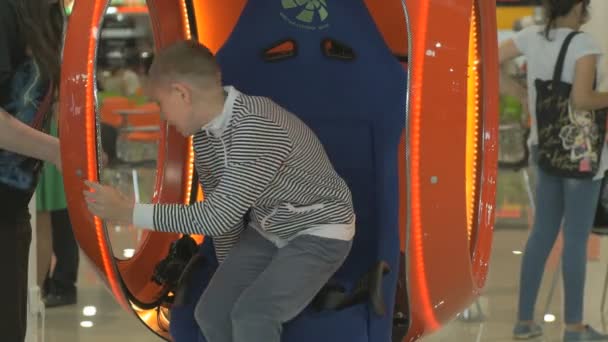Pojke som bär virtuella 3d hjälm sitter på stol — Stockvideo