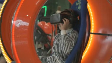 Sandalyede oturan sanal 3d kask giyen çocuk