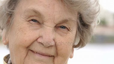 Olgun yaşlı kadın açık havada gülümseyen portresi