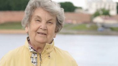 Olgun yaşlı kadın açık havada gülümseyen portresi