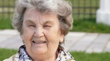 Olgun yaşlı kadın açık havada gülümseyen portresi