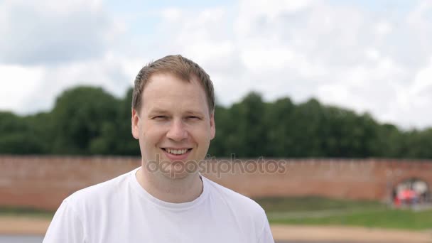 Portret van vrolijke glimlachende jongeman buiten — Stockvideo