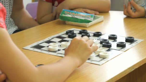 小さな子供たちは、幼稚園でチェッカーをプレイします。クローズ アップ — ストック動画