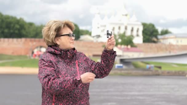 Ενήλικη γυναίκα παίρνει φωτογραφίες χρησιμοποιώντας ασημένιο έξυπνο τηλέφωνο — Αρχείο Βίντεο