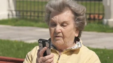 Olgun yaşlı kadın Smartphone açık havada üzerinde söz