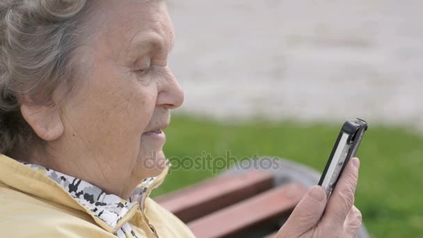 Ältere alte Frau spricht im Freien auf Smartphone — Stockvideo