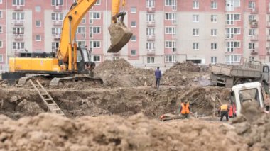 İnşaat için büyük kil çukura inşaatçılar çalışmak