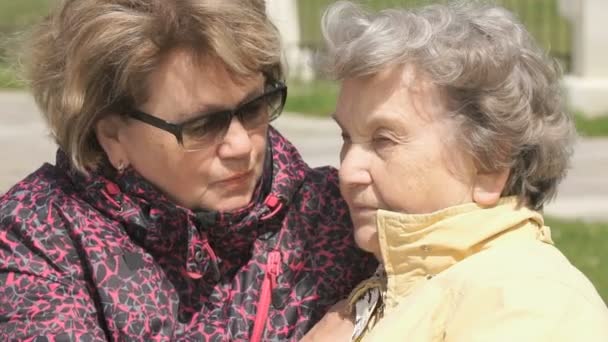 La mujer calma a la anciana durante el estrés al aire libre — Vídeos de Stock