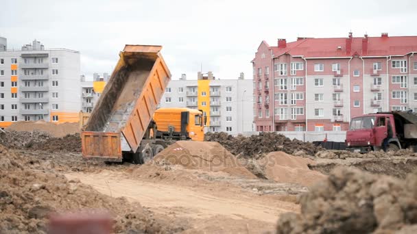 Oranje dump trucks werken op een bouwplaats — Stockvideo