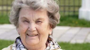 Olgun yaşlı kadın açık havada gülümseyen portresi