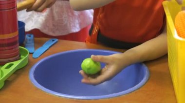 Küçük kız yapay yeşil salatalık temizler