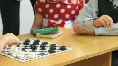 Çocuklar, bir anaokulunda dama oynar. Yakın çekim