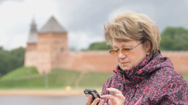 Доросла жінка турист тримає смартфон на відкритому повітрі — стокове відео