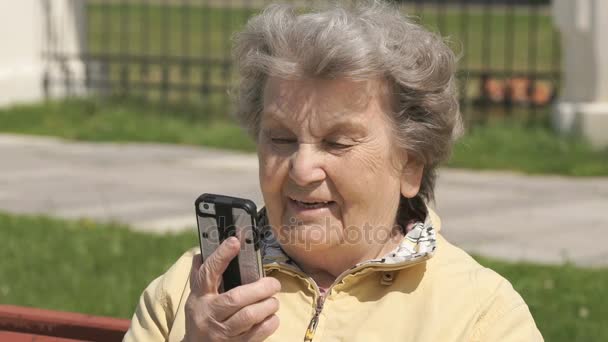 熟女老女屋外で携帯電話で話しています。 — ストック動画