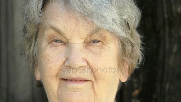 Портрет усміхненої літньої жінки в окулярах — стокове відео