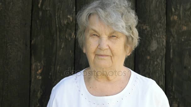 Bejaarde vrouw toont duimen omhoog teken buitenshuis — Stockvideo