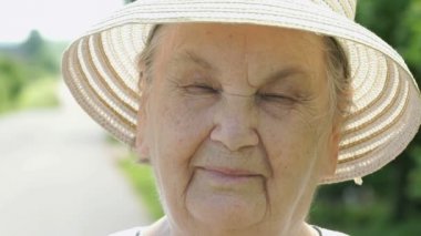 Gülümseyen yaşlı kadın portresi beyaz şapka giymiş