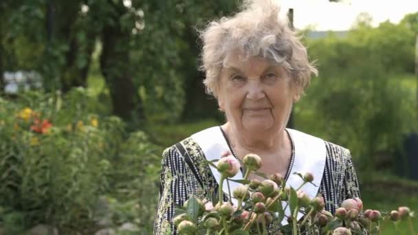 Портрет старої усміхненої жінки в парку — стокове відео