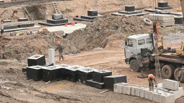 Constructor carga bloques de cimentación utilizando cadenas — Vídeos de Stock