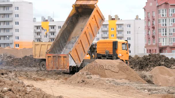 Orangefarbene Muldenkipper auf einer Baustelle — Stockvideo