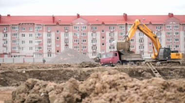 Ekskavatör kova damperli kamyon kullanarak kil yükler