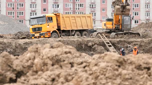 Excavatrice charge l'argile en utilisant le seau dans le camion à benne basculante — Video