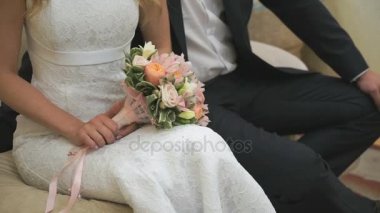 Gelin ve damat kanepede oturan ellerini tutun