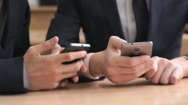 İşadamları yazıyor belgili tanımlık smartphones kullanıldığı metin