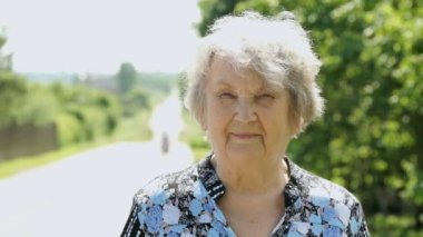 Gülümseyen yaşlı kadın portresi 80s parkta yaşlı