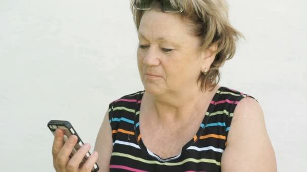 Доросла жінка розмовляє з чоловіком за допомогою смартфона — стокове відео