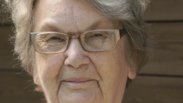 Портрет улыбающейся пожилой женщины в очках — стоковое видео