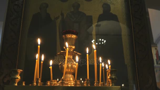 Αναμμένα κεριά εκκλησίας στο ναό. Κοντινό πλάνο — Αρχείο Βίντεο