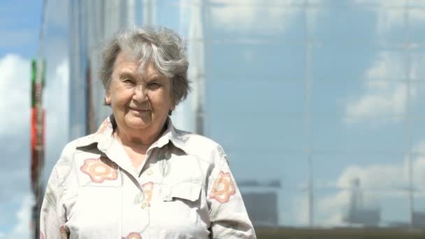Portret uśmiechający się stara kobieta w wieku lat 80-tych na zewnątrz — Wideo stockowe