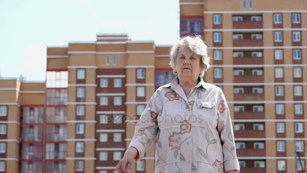 Mosolygó idős asszony emeli kezét fel gombokkal — Stock videók