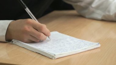 Öğrenci metin egzersiz kalem kullanarak kitapta yazıyor.