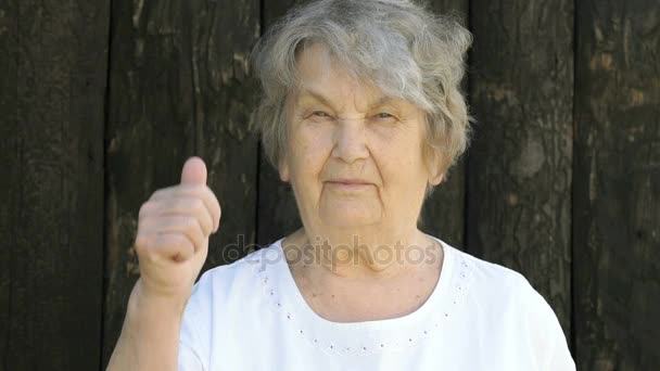 Пожилая женщина показывает большие пальцы на улице — стоковое видео