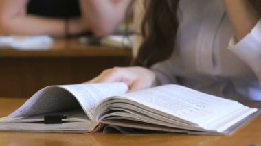 Öğrenci okul kitabın sayfalarını çevirir
