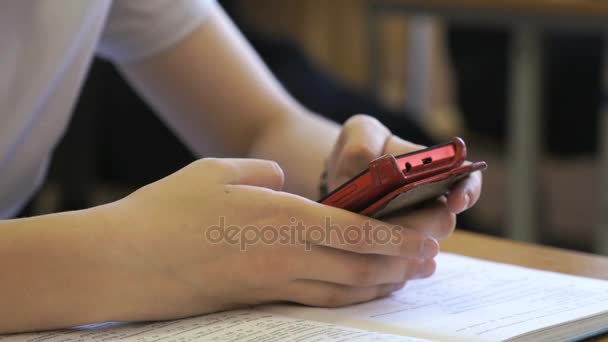 Estudante usando um telefone inteligente vermelho. Close-up — Vídeo de Stock