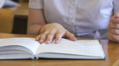 Öğrenci okul kitabın sayfalarını çevirir