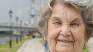 Olgun yaşlı kadın açık havada gülümseyen portresi